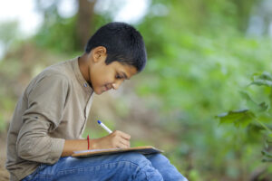 child writing in notebook